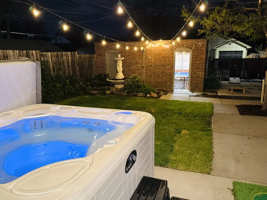 Private hot tub under string lights